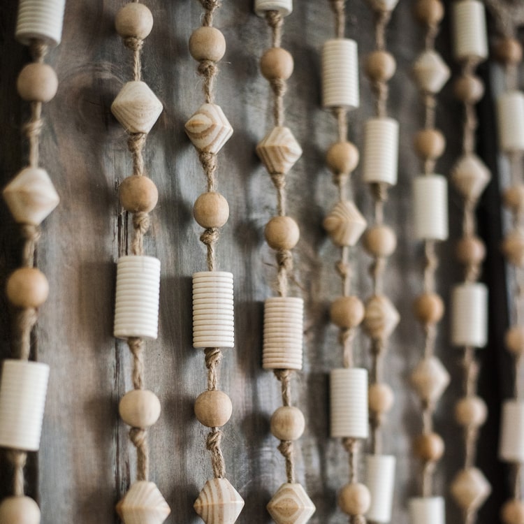 A beautifully crafted Wood Beaded Door Curtain made from solid wood beads and hemp rope, featuring a mix of beige, khaki, and brown colors.