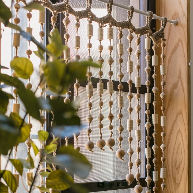 A beautifully crafted Wood Beaded Door Curtain made from solid wood beads and hemp rope, featuring a mix of beige, khaki, and brown colors.