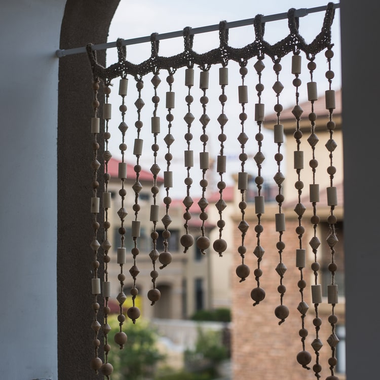 A beautifully crafted Wood Beaded Door Curtain made from solid wood beads and hemp rope, featuring a mix of beige, khaki, and brown colors.