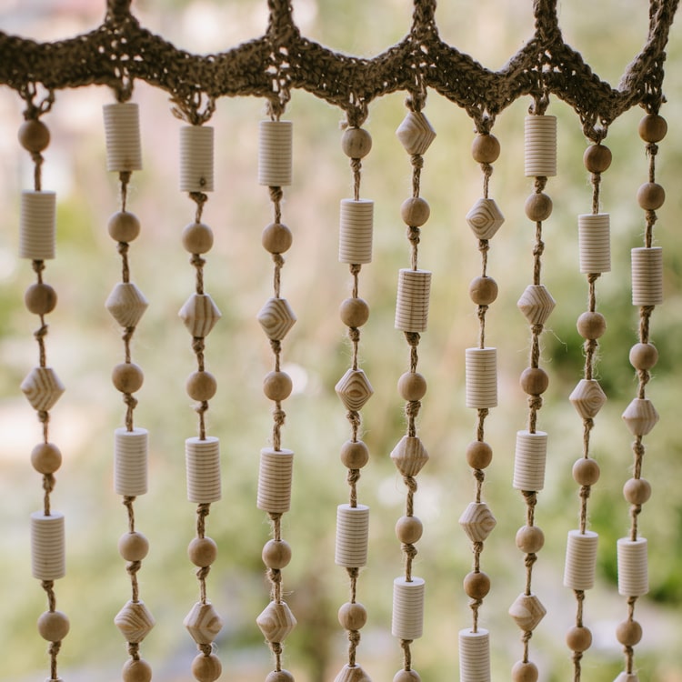 A beautifully crafted Wood Beaded Door Curtain made from solid wood beads and hemp rope, featuring a mix of beige, khaki, and brown colors.