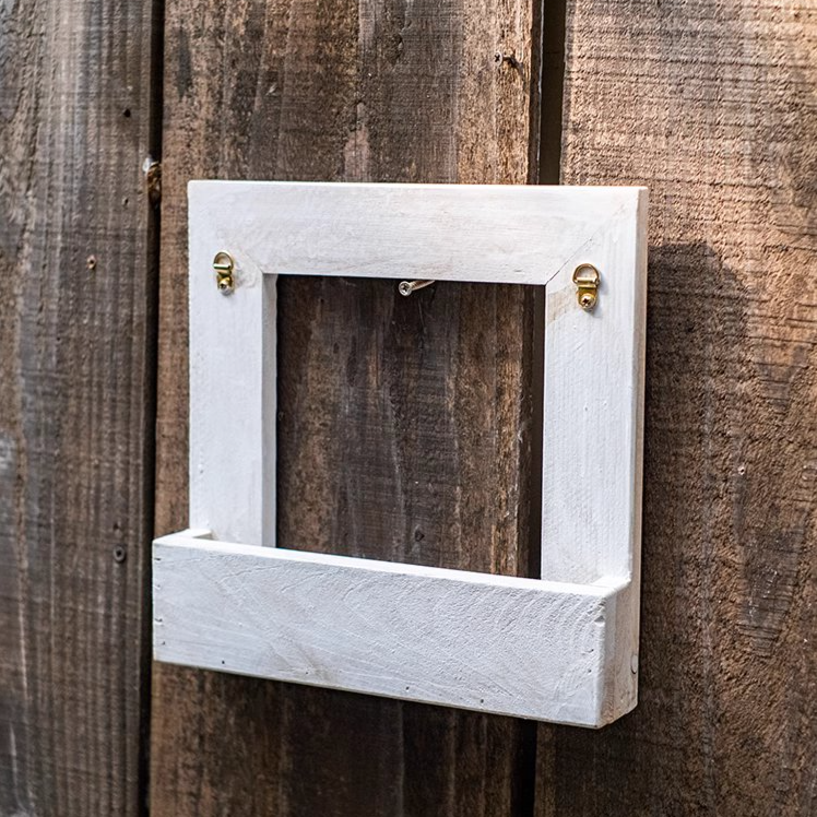 Wood Hanging Floral Frame in white, showcasing plants elegantly on a wall.