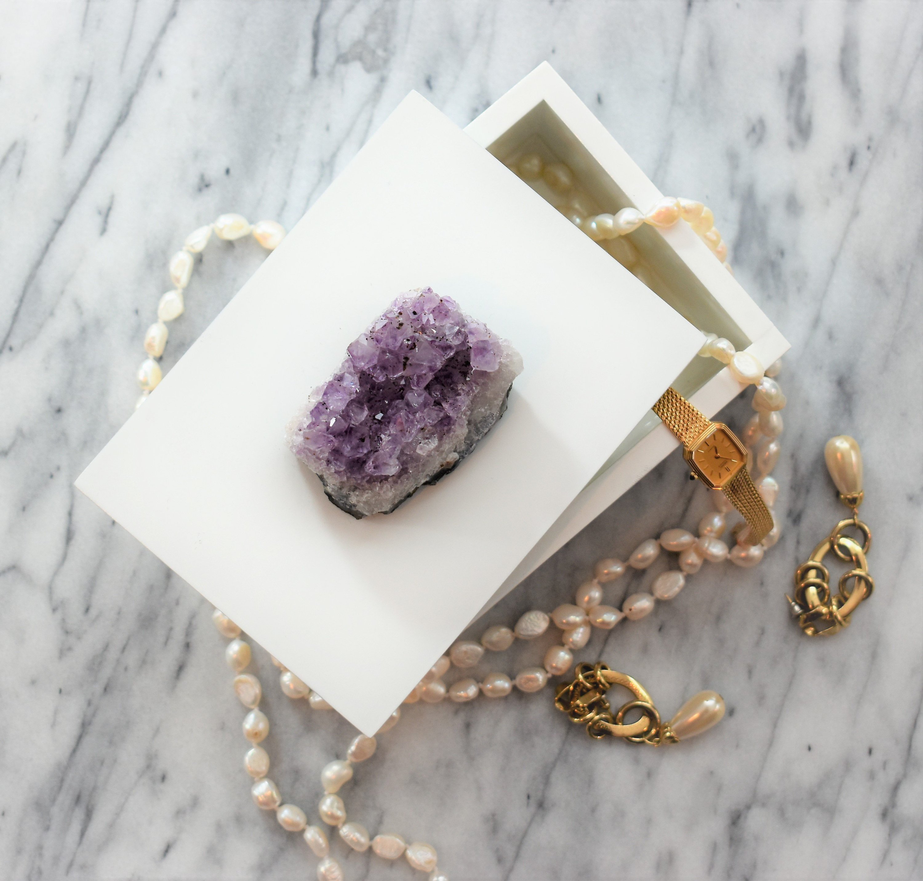 A beautifully crafted wooden box with a raw gemstone on top, showcasing its elegant design and natural materials.