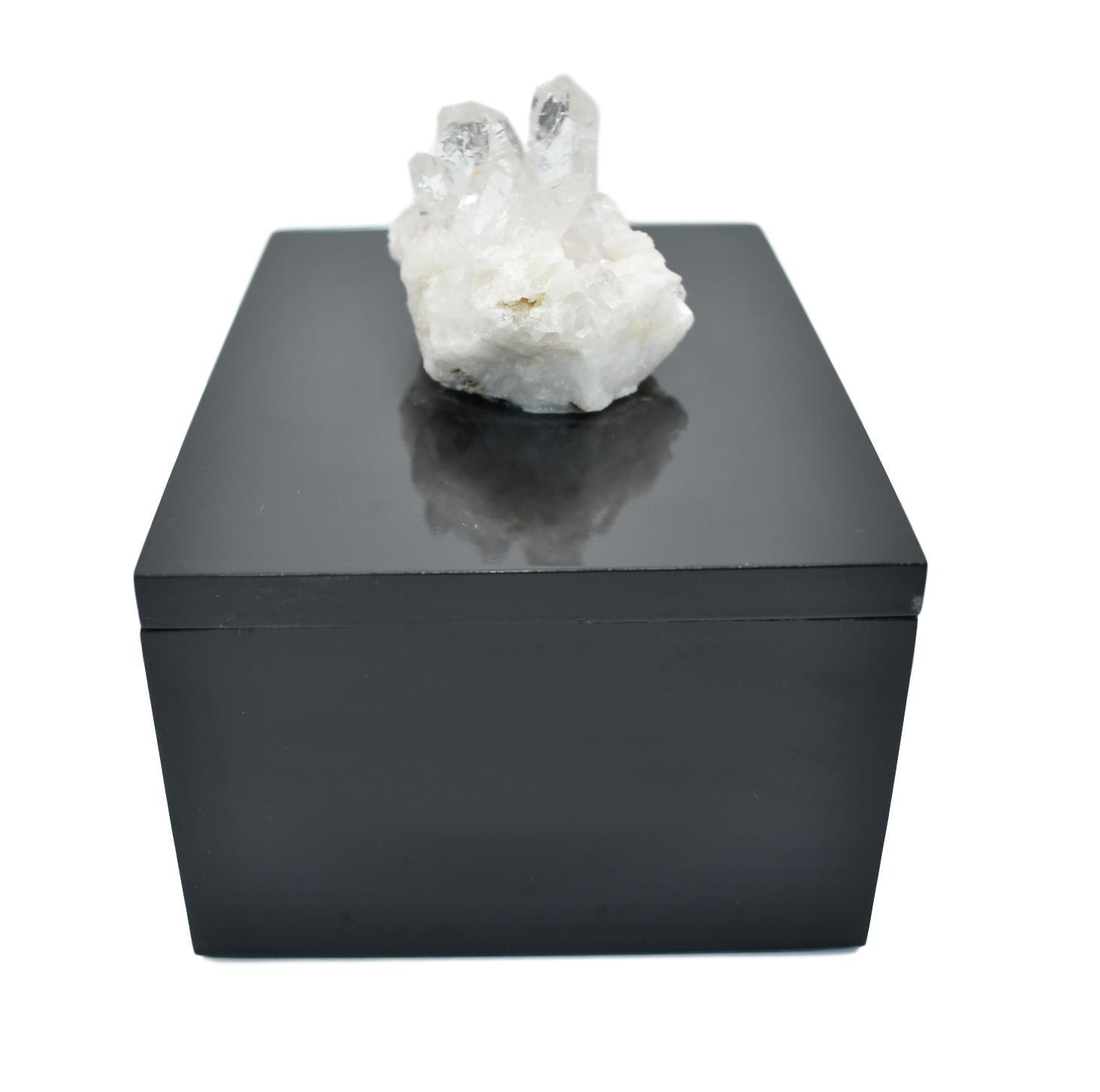 A beautifully crafted wooden box with a raw gemstone on top, showcasing its elegant design and natural materials.