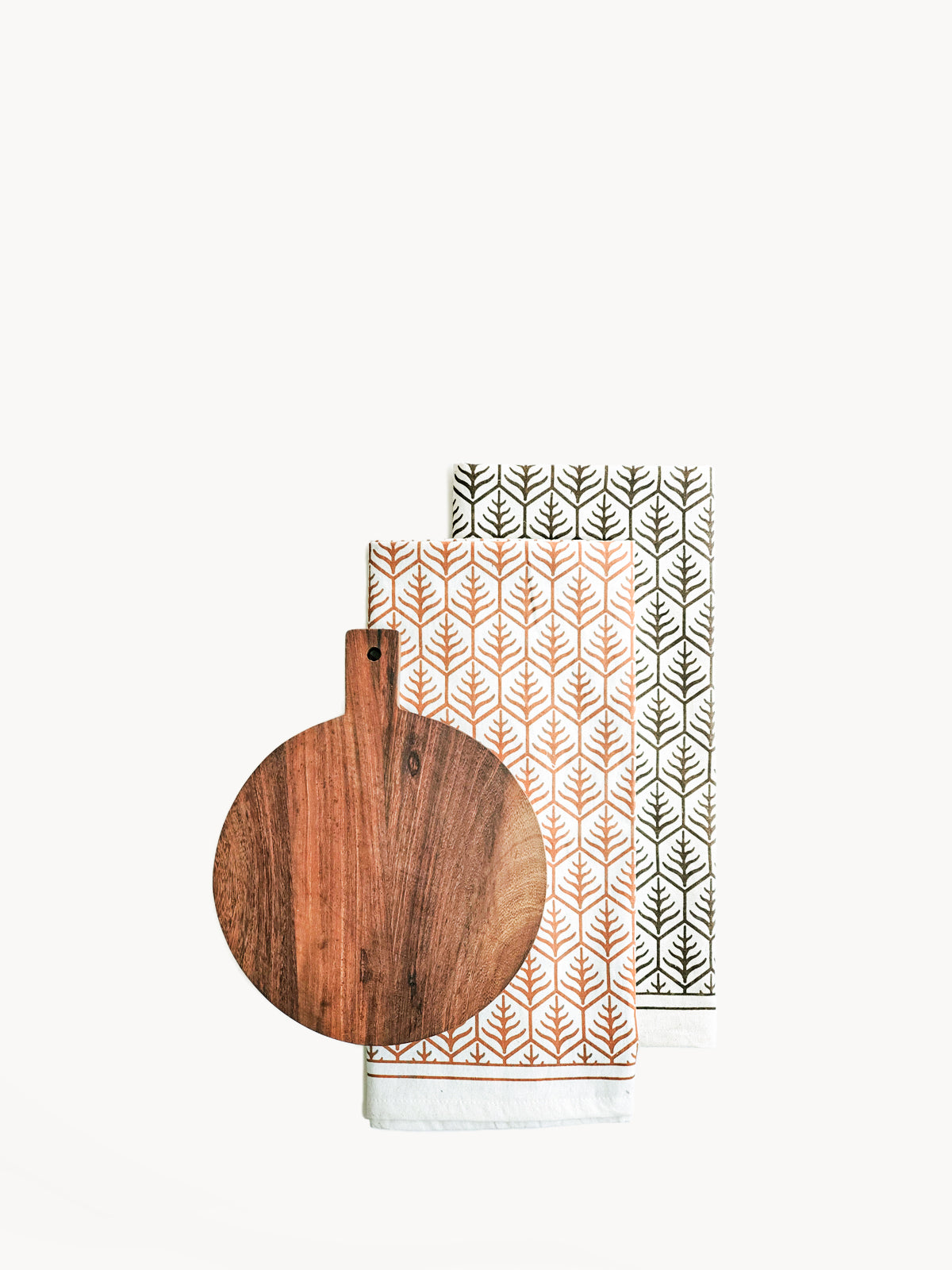 Handcrafted Wooden Round Serving Board with a hand screen-printed tea towel, showcasing natural wood grain and artisan design.