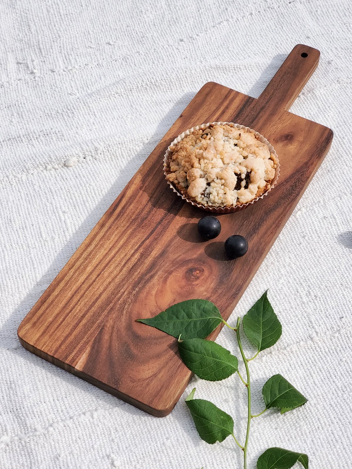 Large handcrafted wooden serving board made from Albizia hardwood, showcasing unique grain patterns and natural finish.