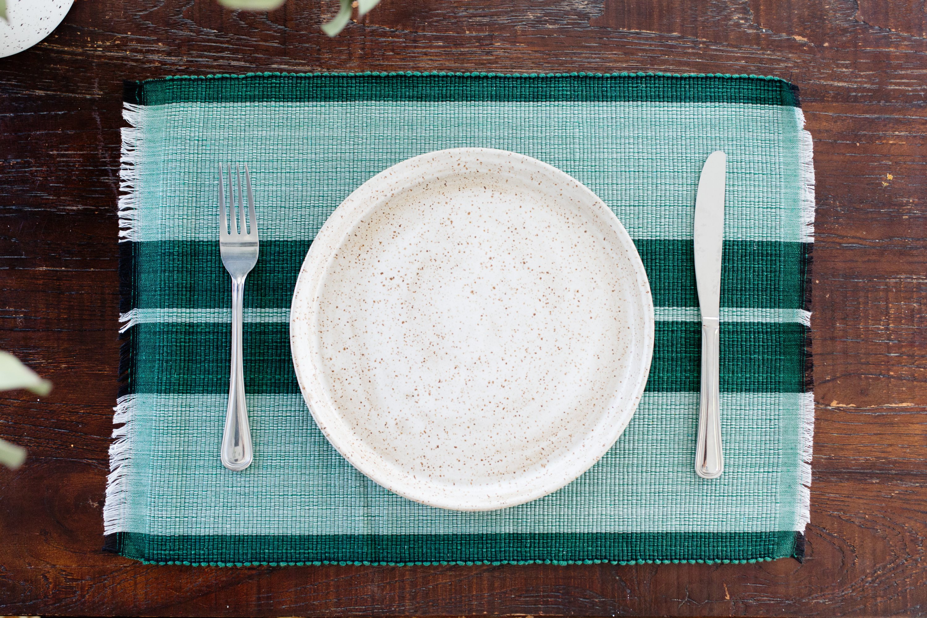 Handcrafted forrest green woven cotton dining placemat showcasing raised ribbed patterns, perfect for enhancing table settings.