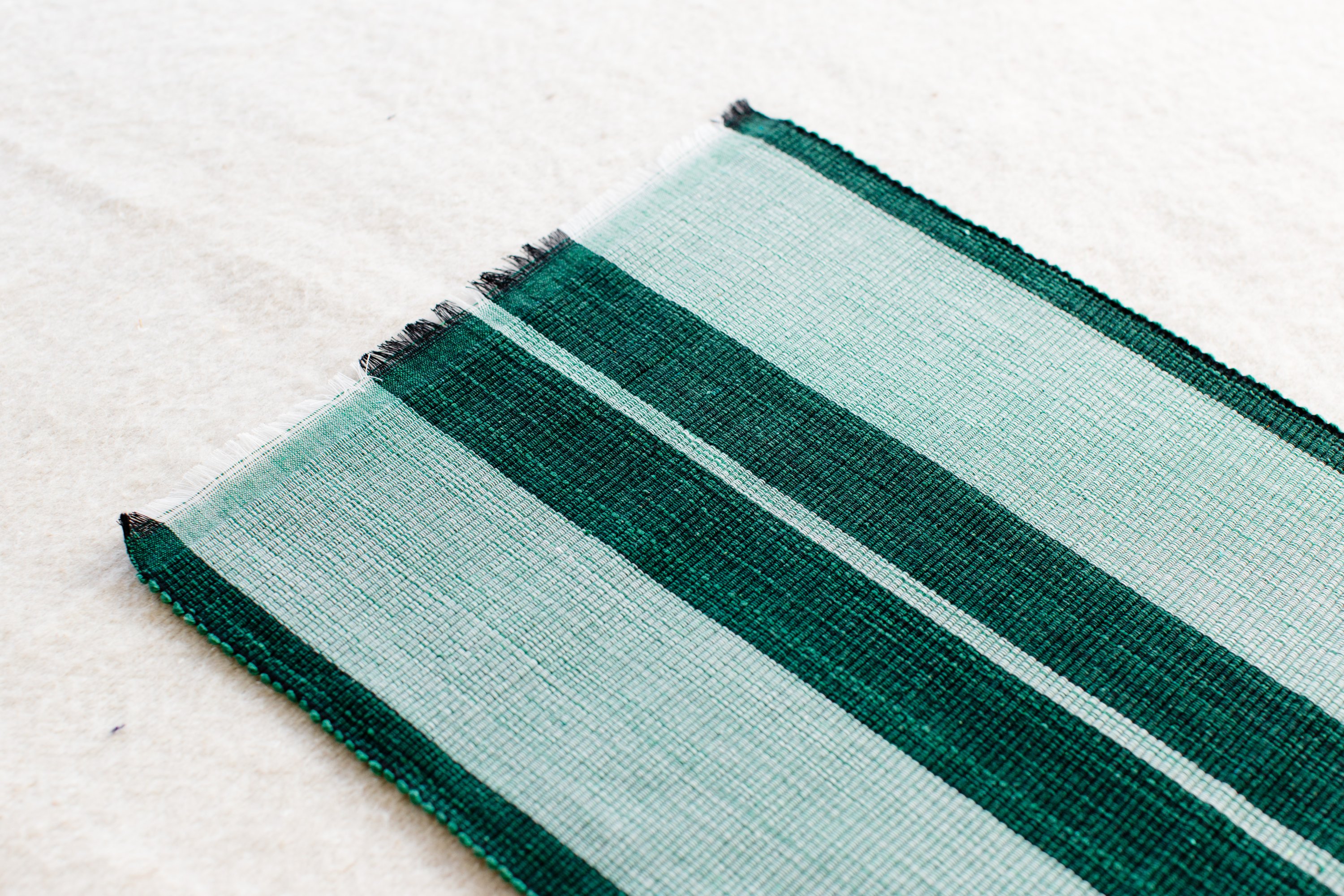 Handcrafted forrest green woven cotton dining placemat showcasing raised ribbed patterns, perfect for enhancing table settings.