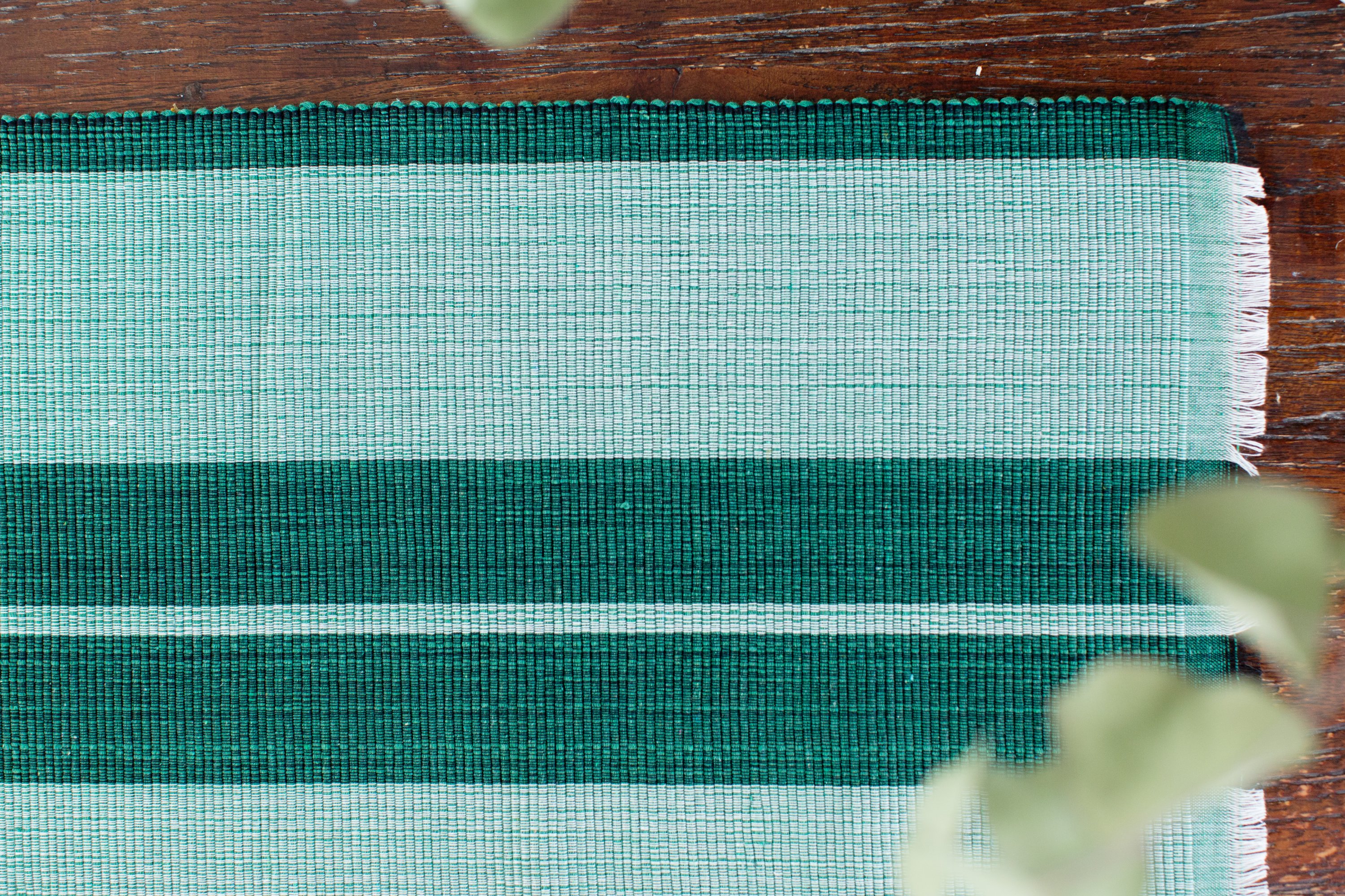 Handcrafted forrest green woven cotton dining placemat showcasing raised ribbed patterns, perfect for enhancing table settings.