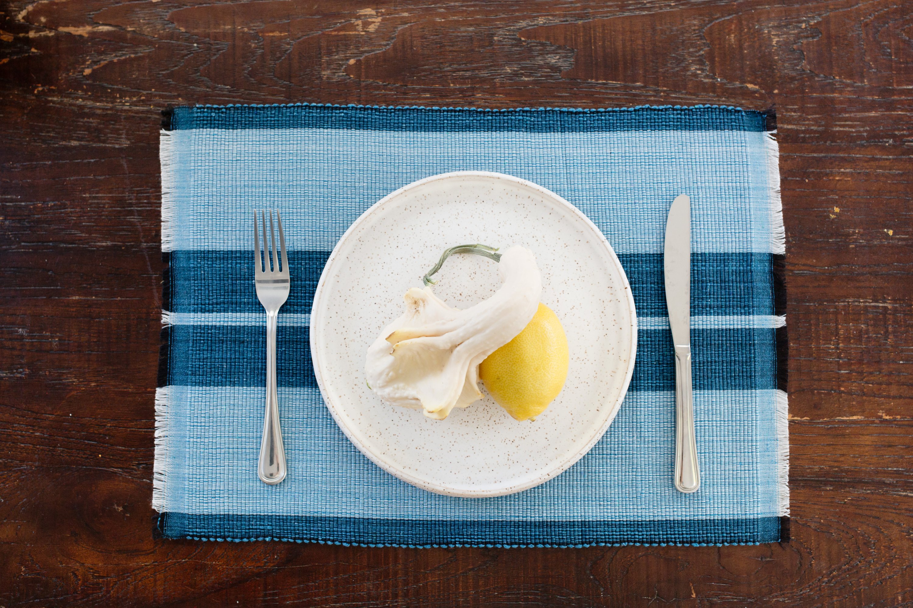 Ocean blue woven cotton dining placemat with raised ribbed patterns, handcrafted by local artisans.