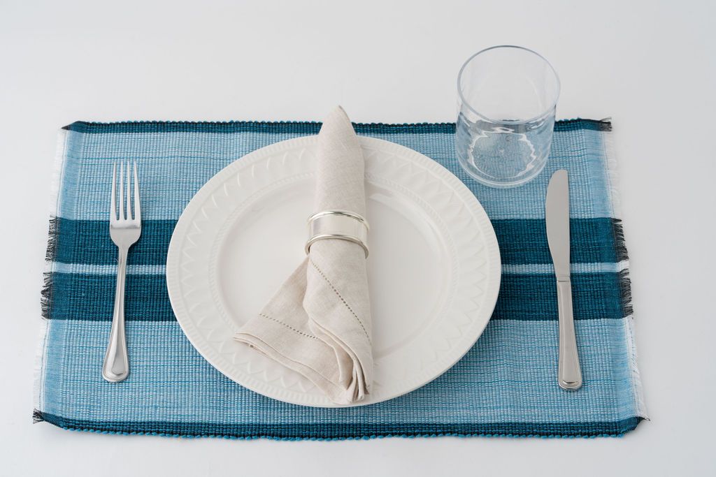 Ocean blue woven cotton dining placemat with raised ribbed patterns, handcrafted by local artisans.