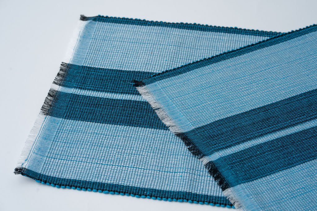 Ocean blue woven cotton dining placemat with raised ribbed patterns, handcrafted by local artisans.