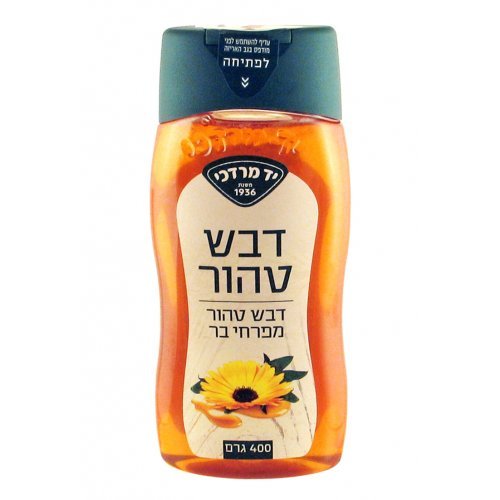 A jar of Yad Mordechai Pure Israeli Wildflower Honey with a golden hue, surrounded by wildflowers, showcasing its natural purity and rich flavor.