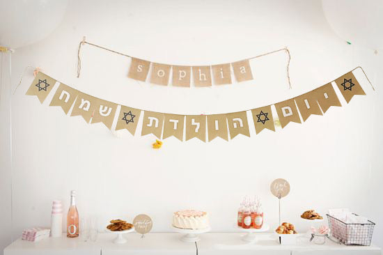 Yom Huledet Sameach burlap banner hanging at a birthday party, featuring festive lettering in Hebrew.