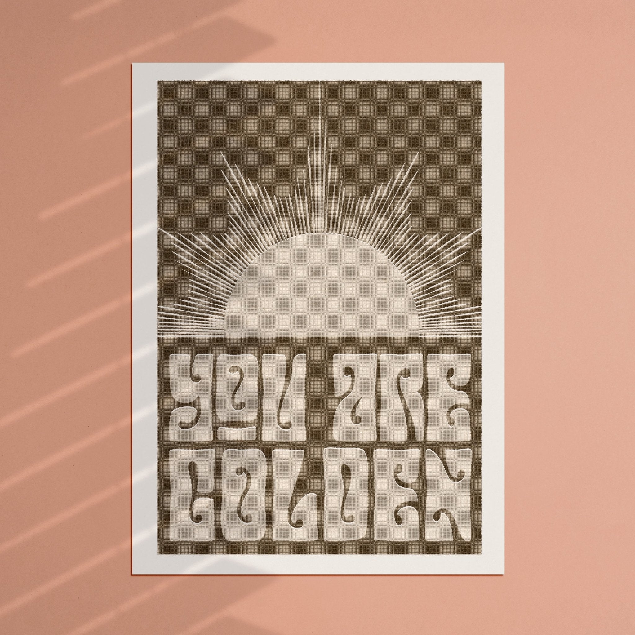 You Are Golden art print featuring retro typography and a minimal sun design in sepia and pink-green options.