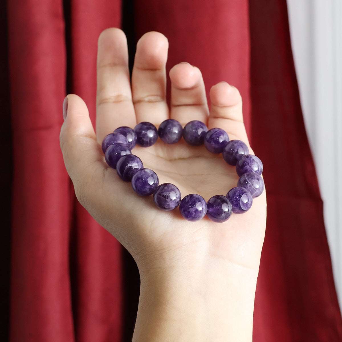 Amethyst Round Beads Bracelet showcasing natural purple crystals in various sizes, elegantly strung on an elastic band.