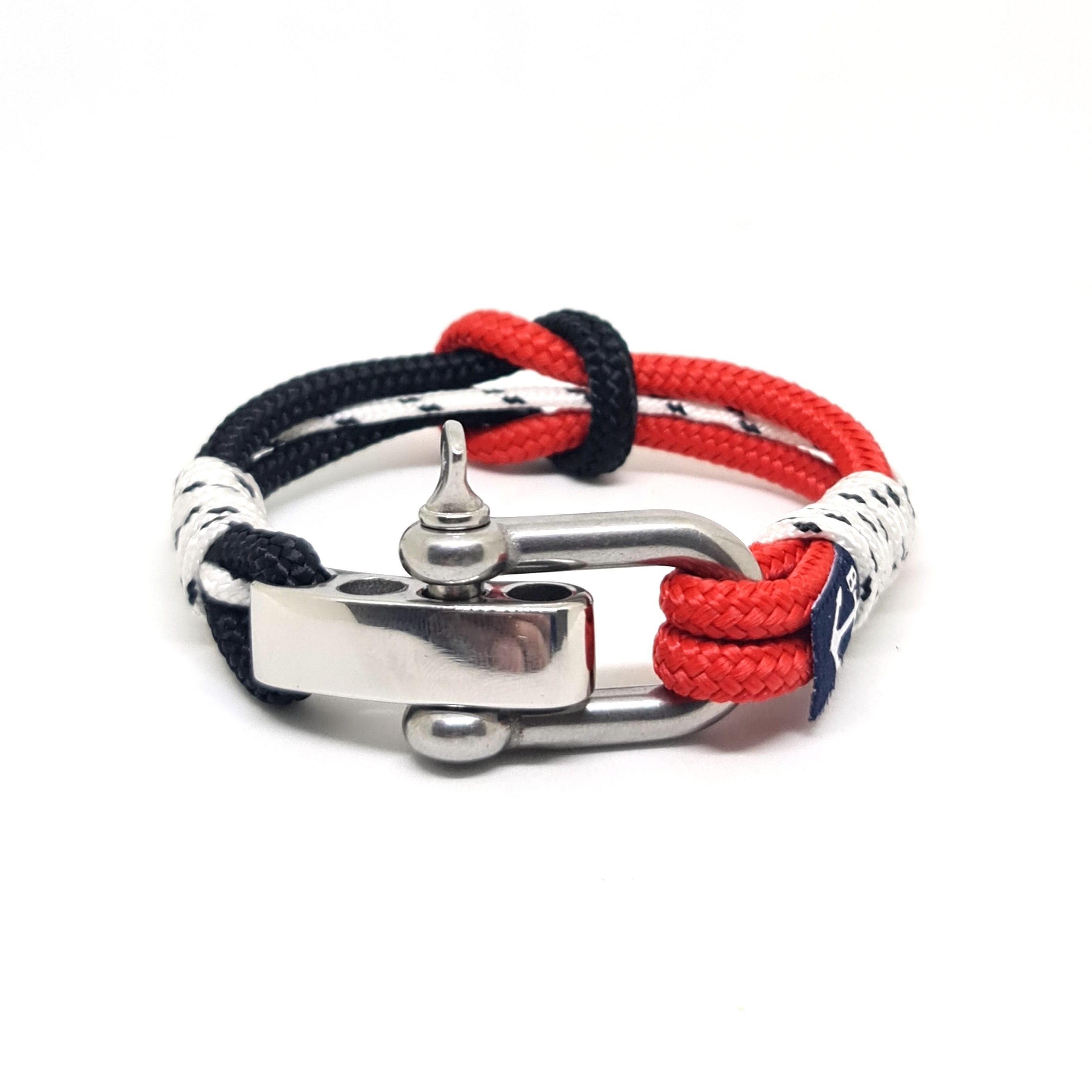 Banshee Nautical Bracelet featuring blue and red sailing ropes with a stainless steel shackle, elegantly displayed on a wooden surface.