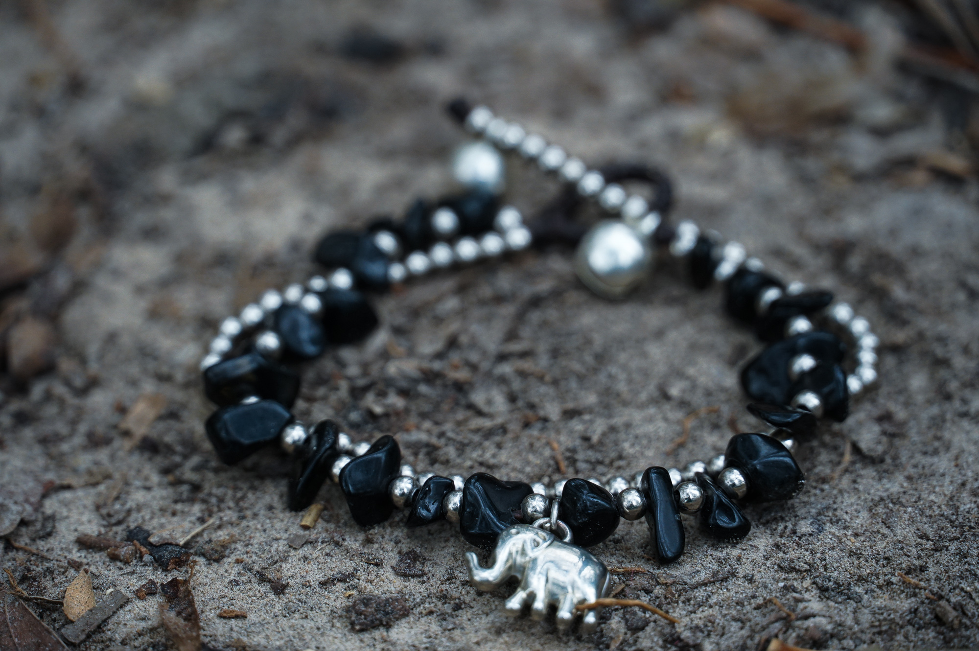 A beautifully handcrafted Boho Elephant Silver Stone Bracelet featuring elephant silver, natural stones, and pressed cotton cord, showcasing a unique bohemian design.