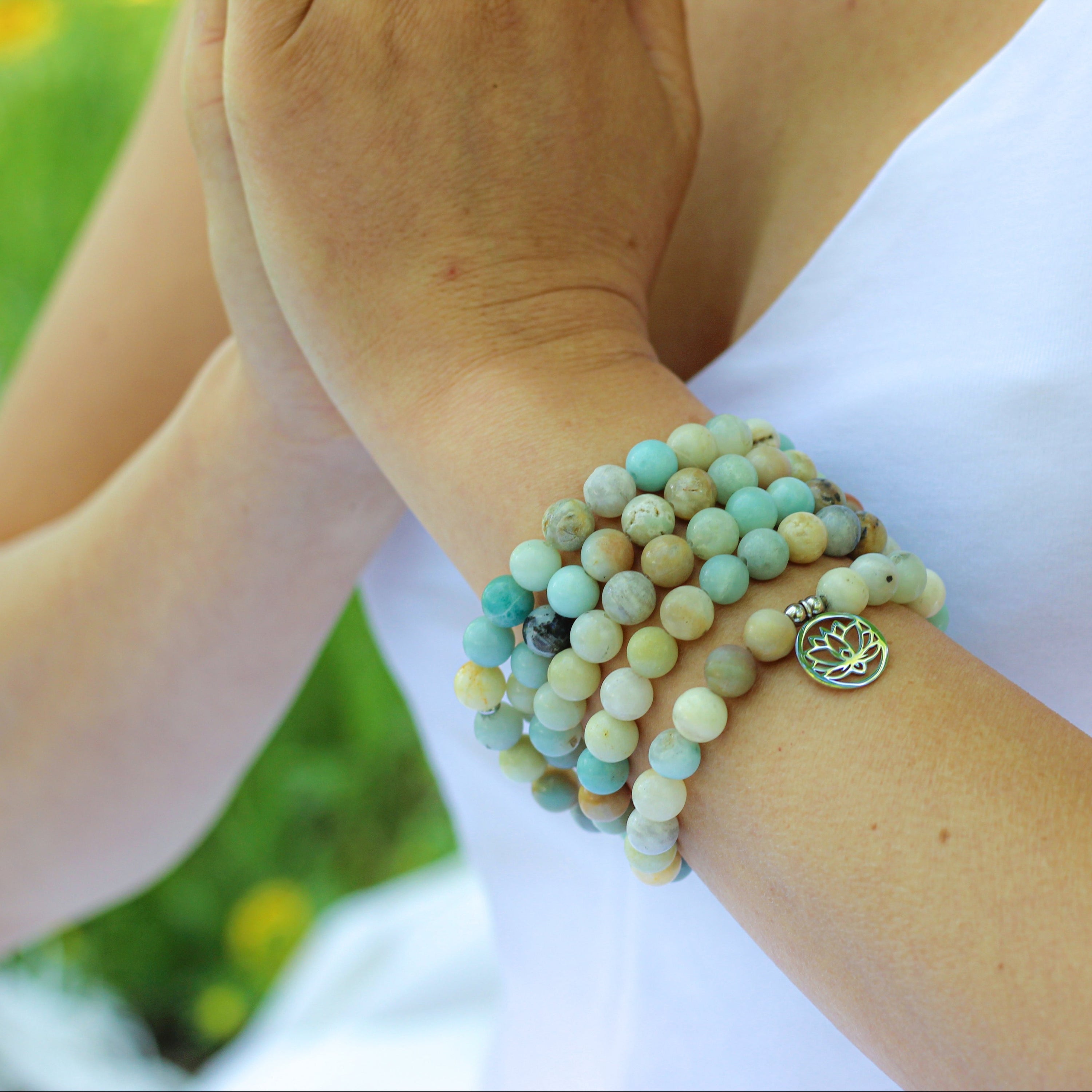 Bracelet Mala 'Lotus' de 108 perles en Amazonite avec pendentif en acier inoxydable, symbolisant la paix intérieure et l'épanouissement spirituel.