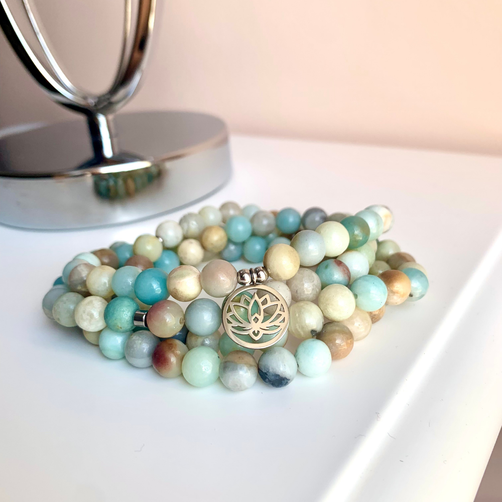 Bracelet Mala 'Lotus' de 108 perles en Amazonite avec pendentif en acier inoxydable, symbolisant la paix intérieure et l'épanouissement spirituel.