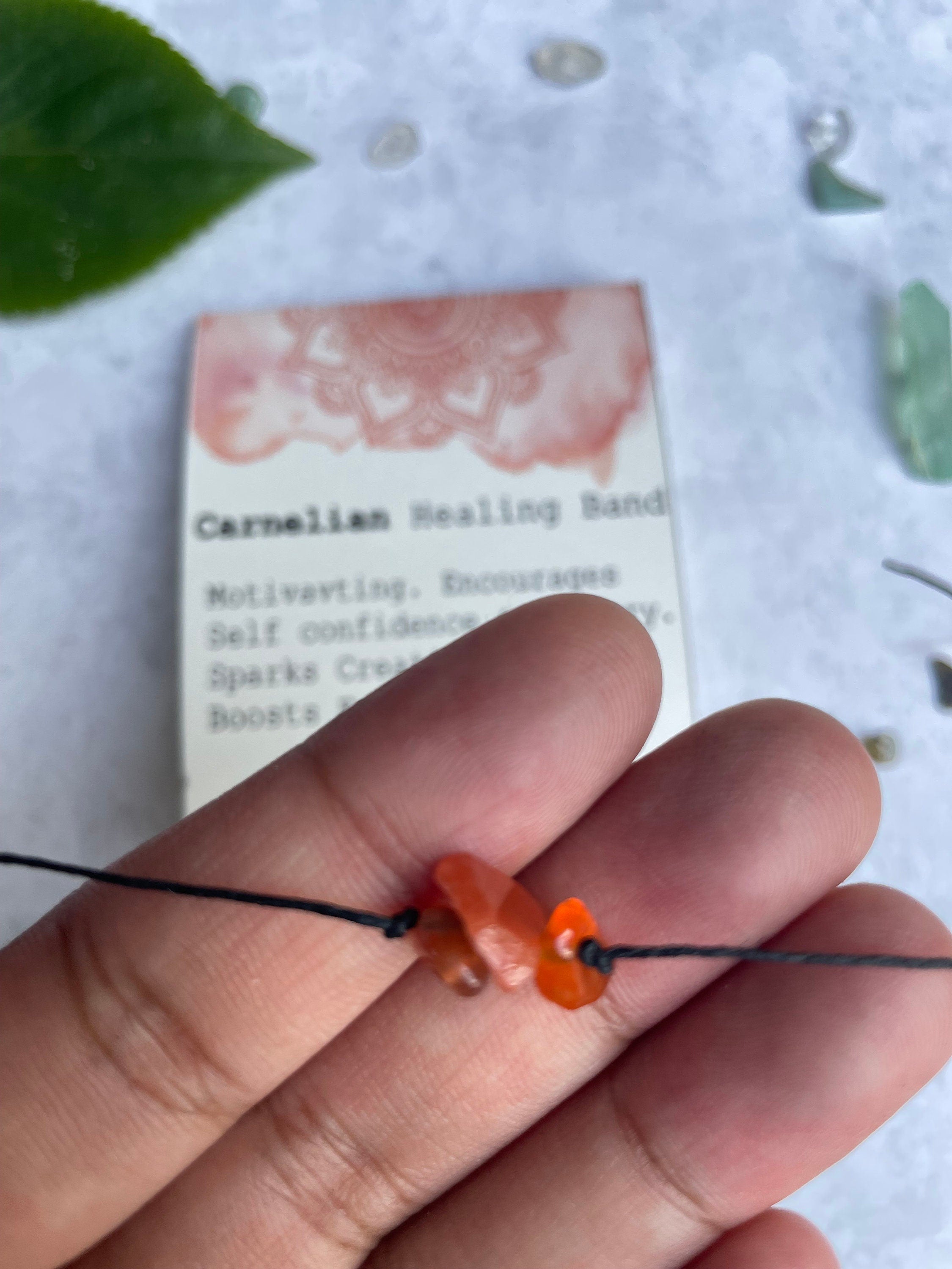 A handcrafted Carnelian Healing Band featuring natural gemstones, tied with a closure, showcasing its unique design and vibrant colors.