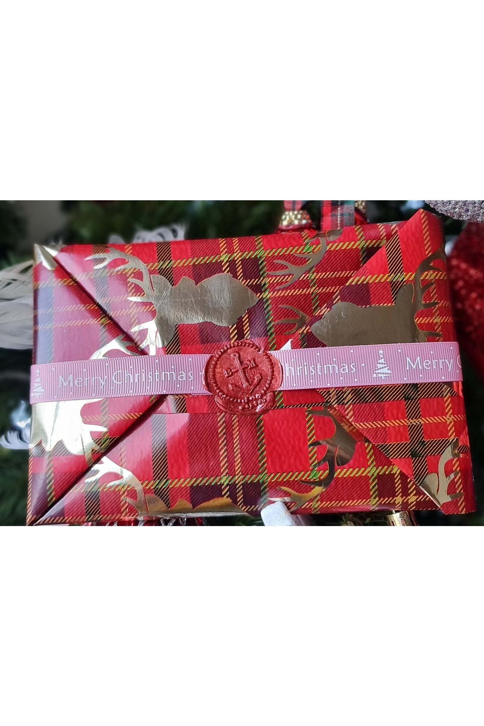 A beautifully wrapped Christmas gift with festive paper and a hand-written card attached, showcasing holiday cheer.