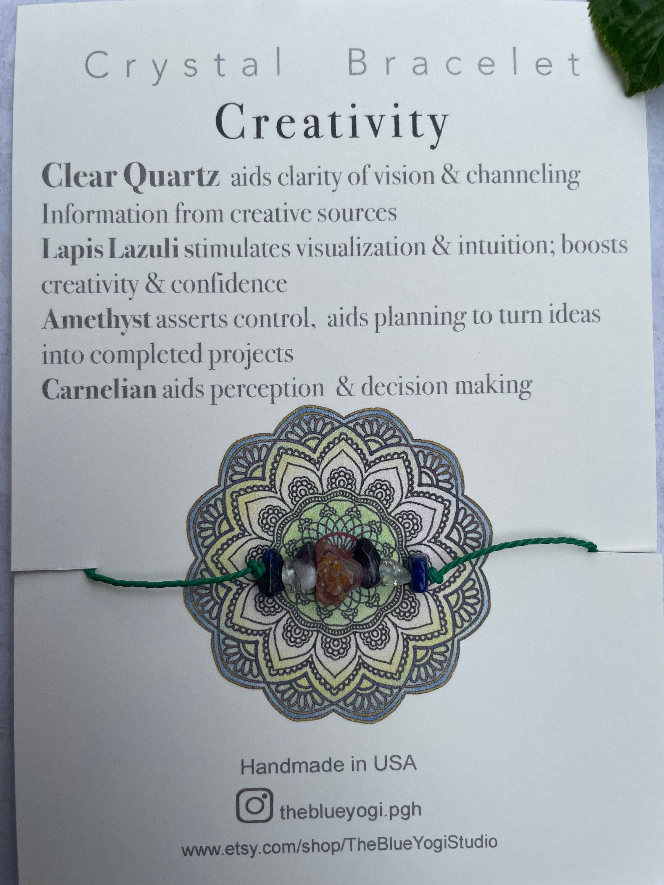 A handcrafted Creativity Bracelet featuring natural gemstones with a tie closure, displayed alongside a watercolor Mandala art card.