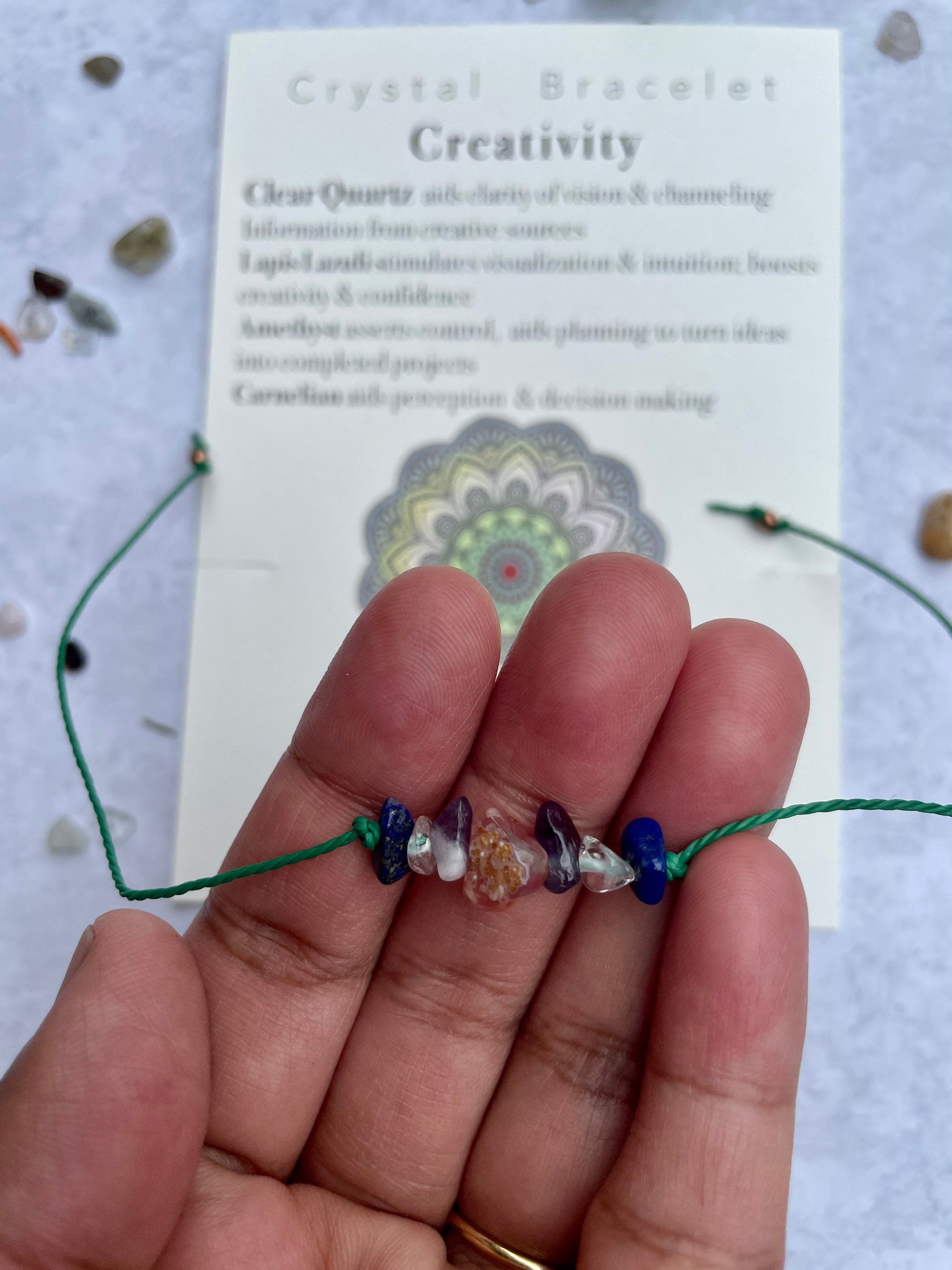 A handcrafted Creativity Bracelet featuring natural gemstones with a tie closure, displayed alongside a watercolor Mandala art card.