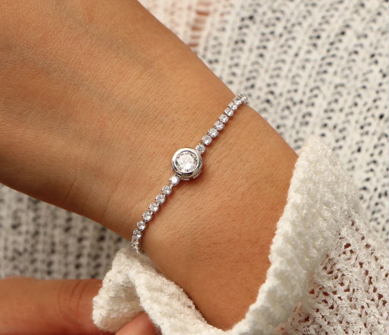 A beautiful Crystal Tennis Bracelet featuring sparkling cubic zirconia stones, available in rose gold and silver finishes, showcasing its adjustable design.