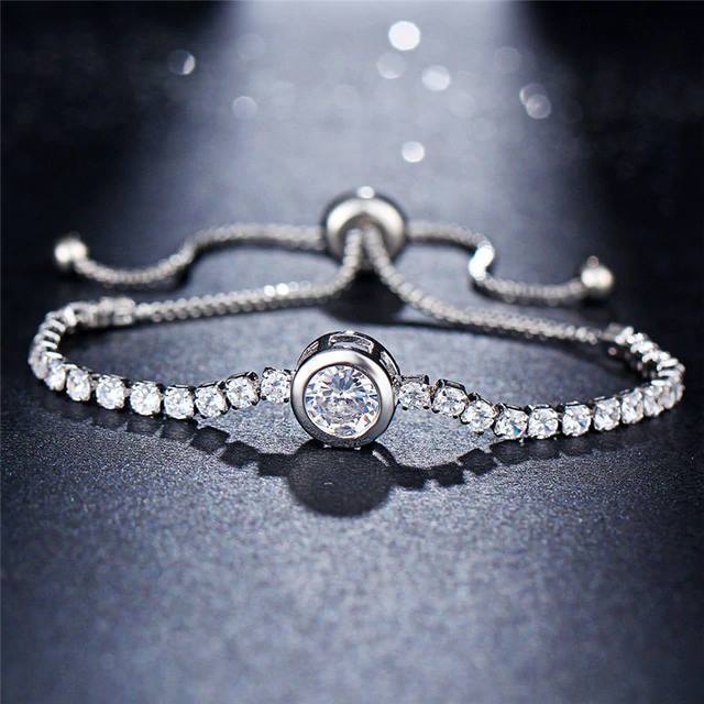 A beautiful Crystal Tennis Bracelet featuring sparkling cubic zirconia stones, available in rose gold and silver finishes, showcasing its adjustable design.