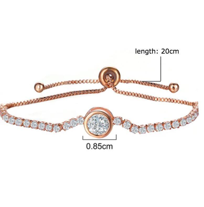 A beautiful Crystal Tennis Bracelet featuring sparkling cubic zirconia stones, available in rose gold and silver finishes, showcasing its adjustable design.