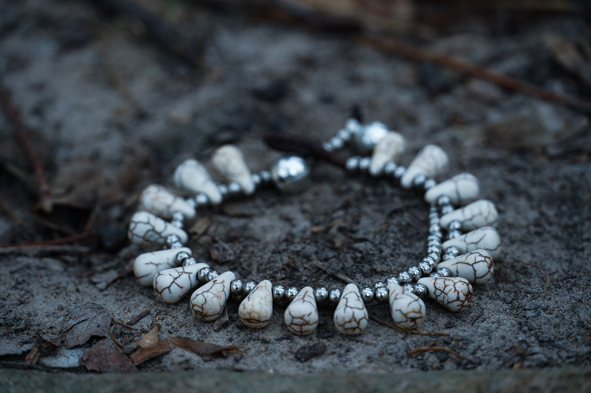 A pair of handmade double stranded boho silver bracelets featuring natural stones and pressed cotton cord, showcasing a chic and unique design.