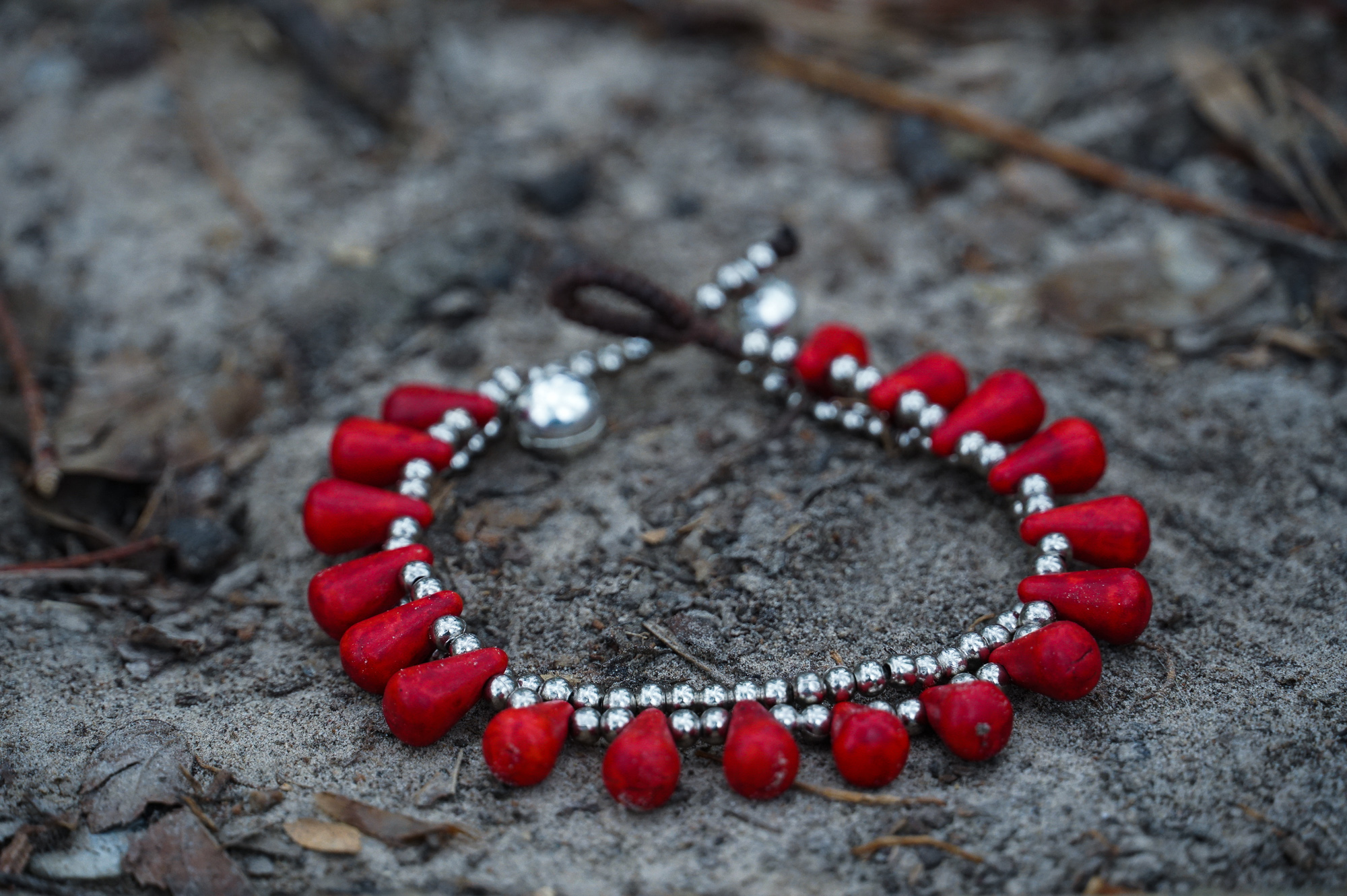 A pair of handmade double stranded boho silver bracelets featuring natural stones and pressed cotton cord, showcasing a chic and unique design.