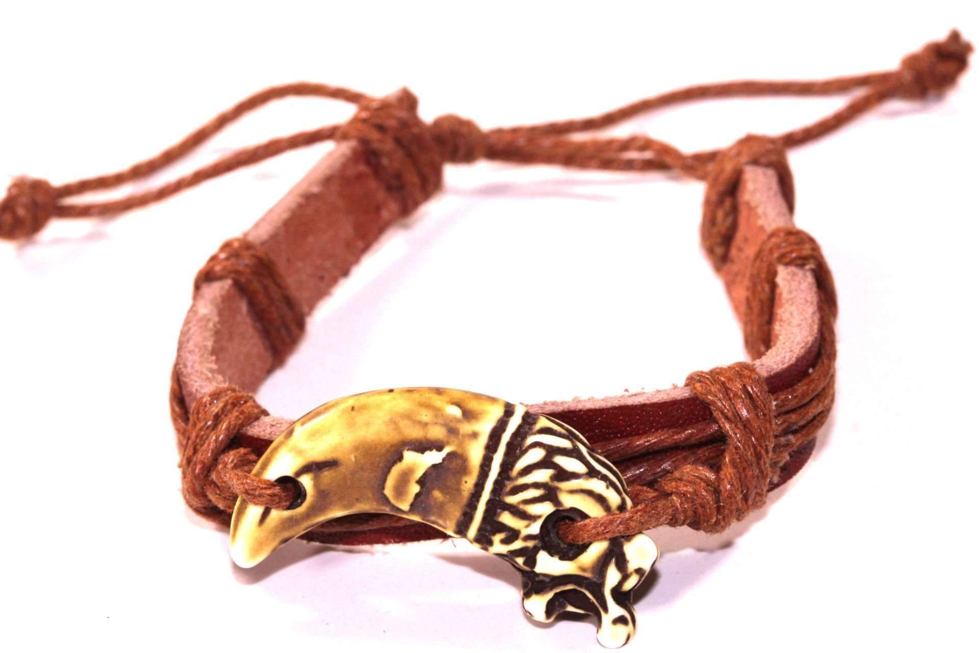 A beautifully handmade Dragon Tooth Leather Bracelet featuring a carved dragon design on a leather band with an adjustable rope-like chord.