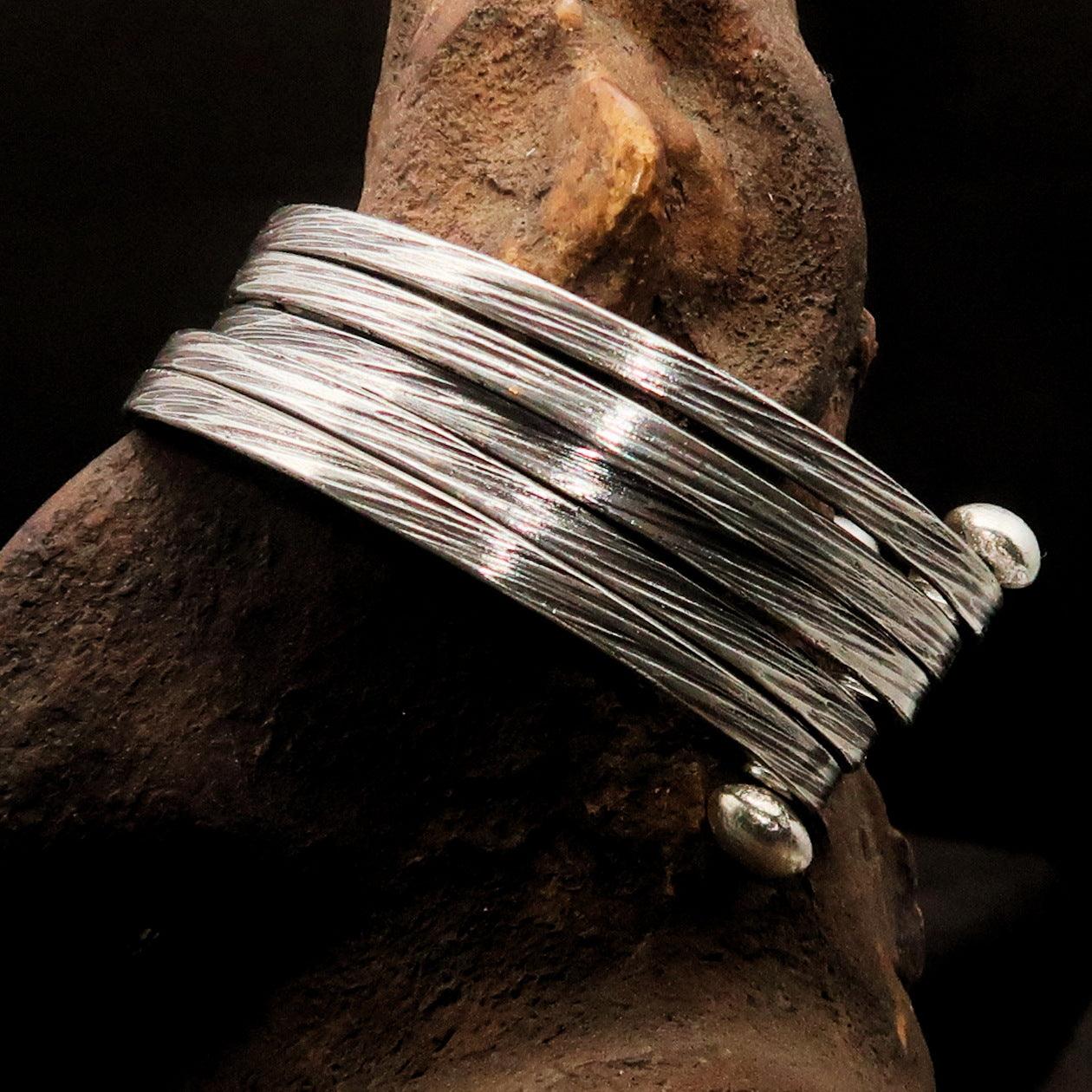 A beautifully handcrafted minimalistic 5 String Sterling Silver Bracelet showcasing its flexible design and hallmark 925.