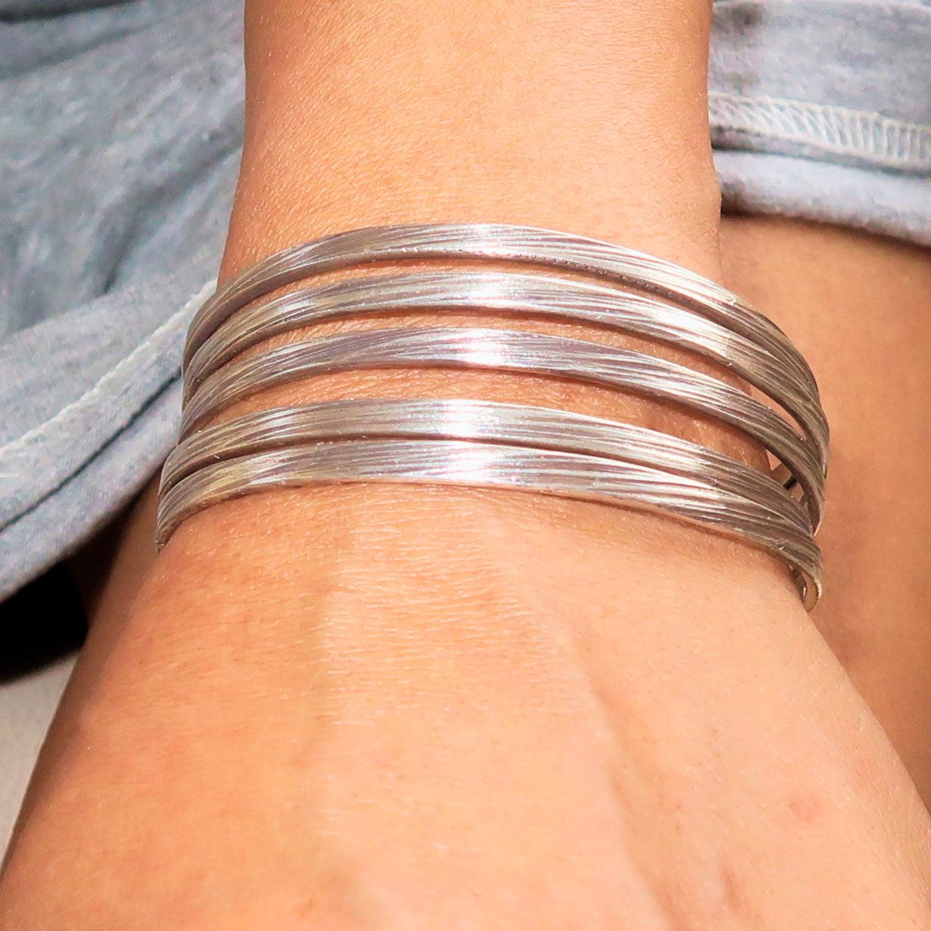 A beautifully handcrafted minimalistic 5 String Sterling Silver Bracelet showcasing its flexible design and hallmark 925.