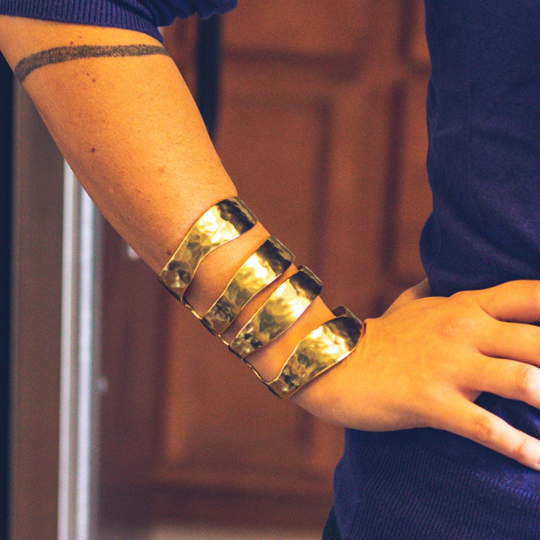 A stunning Four Row Cuff Bracelet made of textured metal with asymmetrical cut-outs, available in gold, silver, and rose gold finishes.