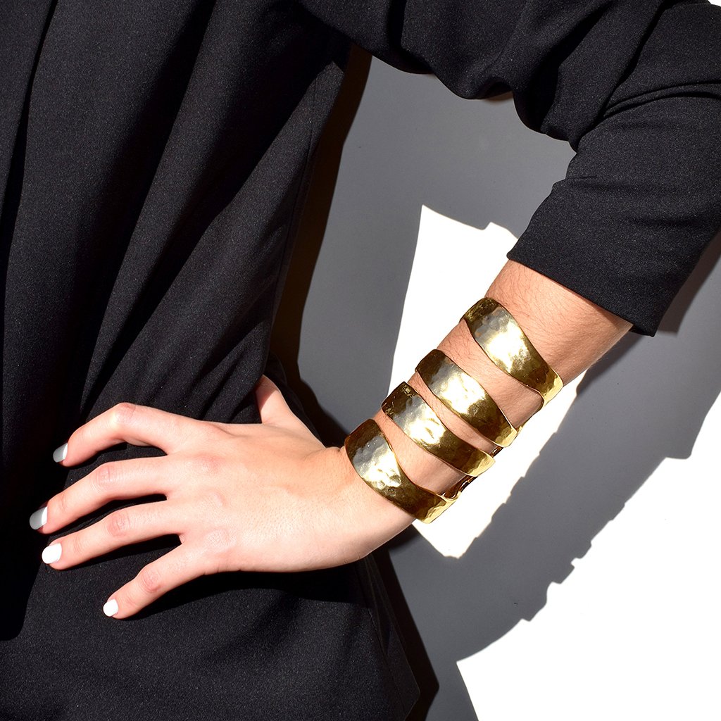 A stunning Four Row Cuff Bracelet made of textured metal with asymmetrical cut-outs, available in gold, silver, and rose gold finishes.