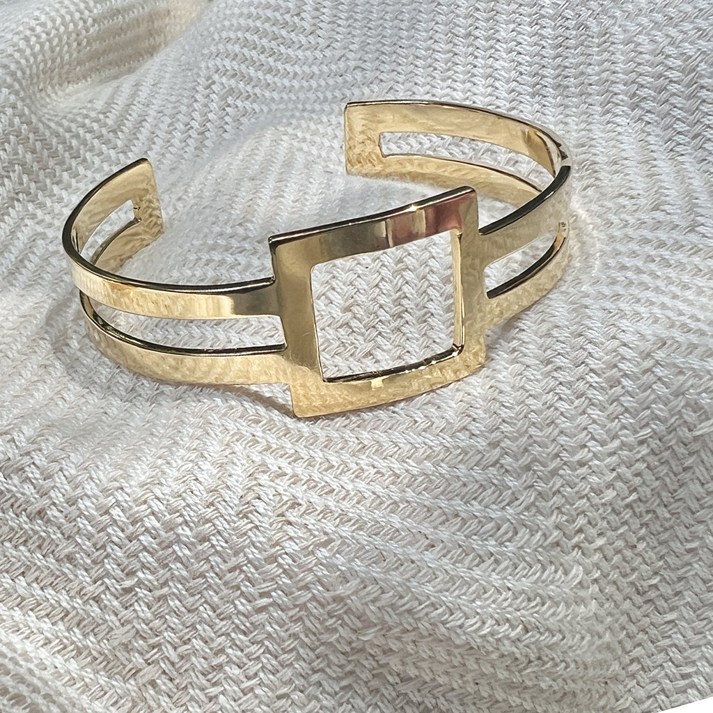 Geo Stripe Bombshell Cuff featuring two parallel bars and a square centerpiece, handcrafted from recycled materials with gold plating.