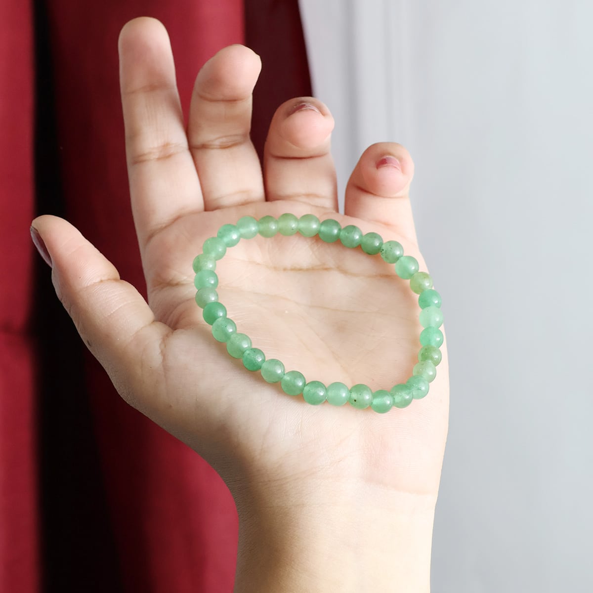 A close-up view of a Green Aventurine Round Beads Bracelet showcasing its natural green stones and elastic design.