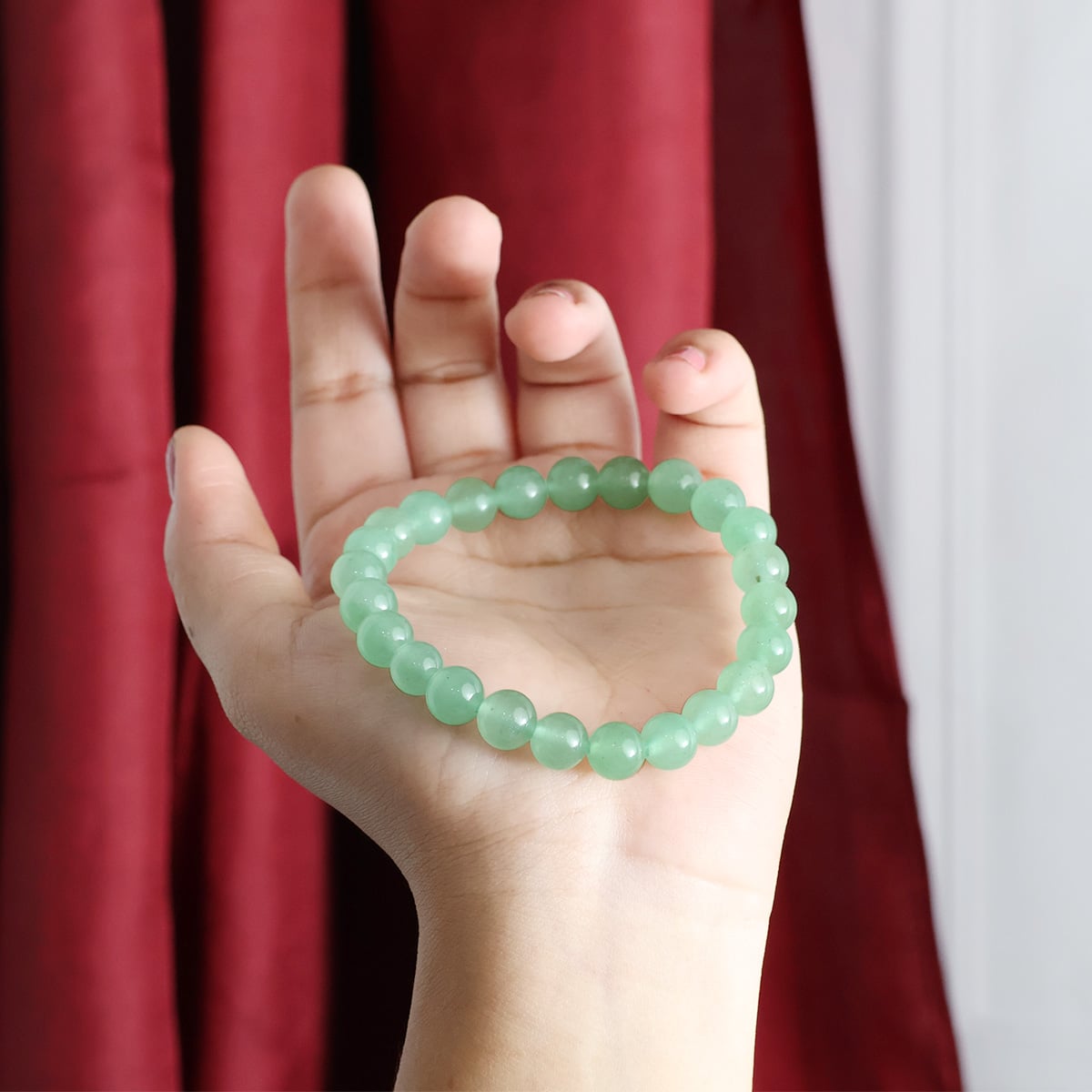 A close-up view of a Green Aventurine Round Beads Bracelet showcasing its natural green stones and elastic design.