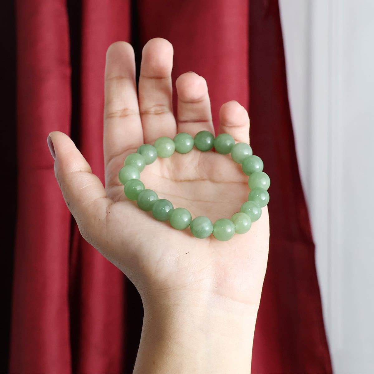 A close-up view of a Green Aventurine Round Beads Bracelet showcasing its natural green stones and elastic design.