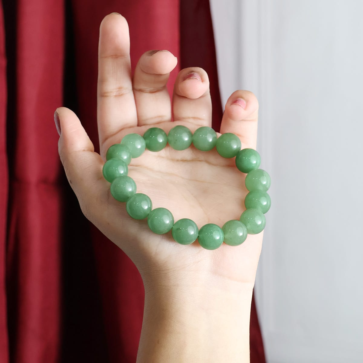 A close-up view of a Green Aventurine Round Beads Bracelet showcasing its natural green stones and elastic design.