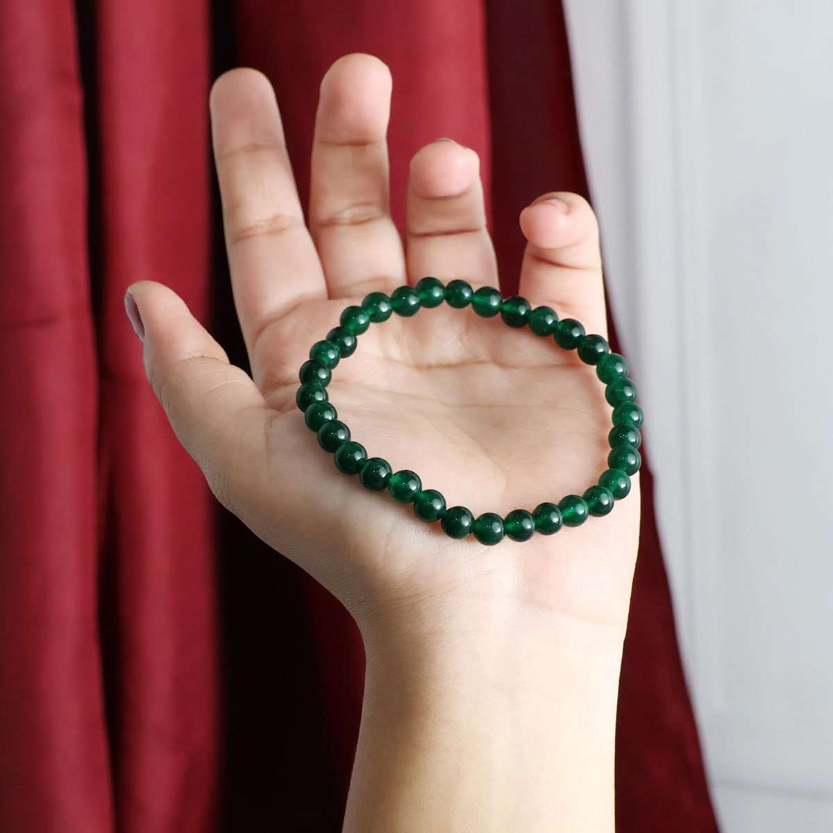 A beautiful Green Jade Round Beads Bracelet showcasing natural jade beads in various sizes, elegantly strung on an elastic band.