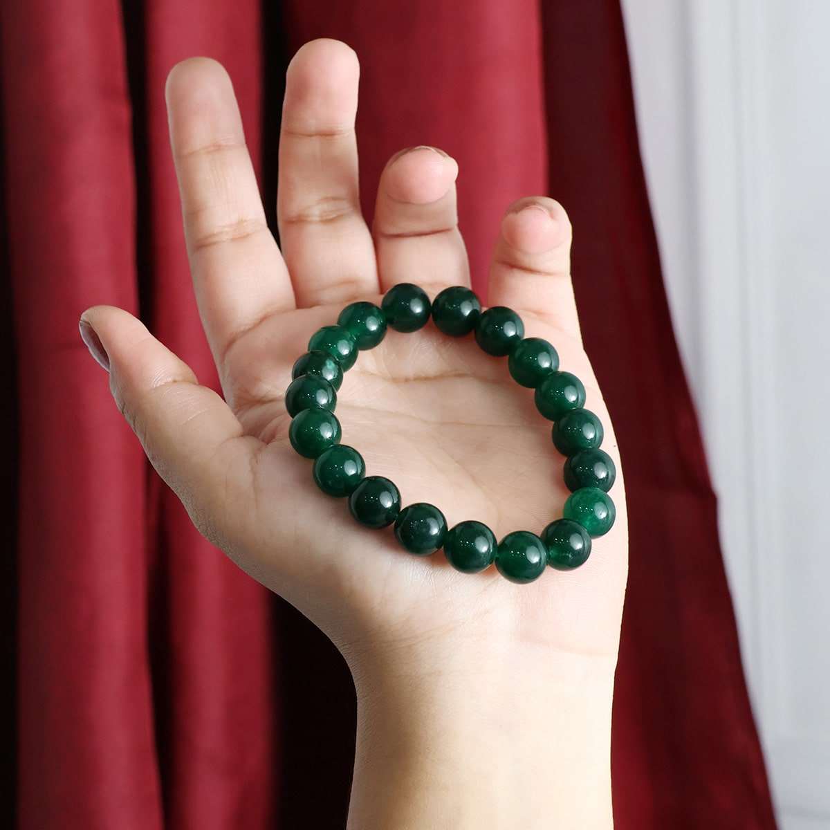 A beautiful Green Jade Round Beads Bracelet showcasing natural jade beads in various sizes, elegantly strung on an elastic band.