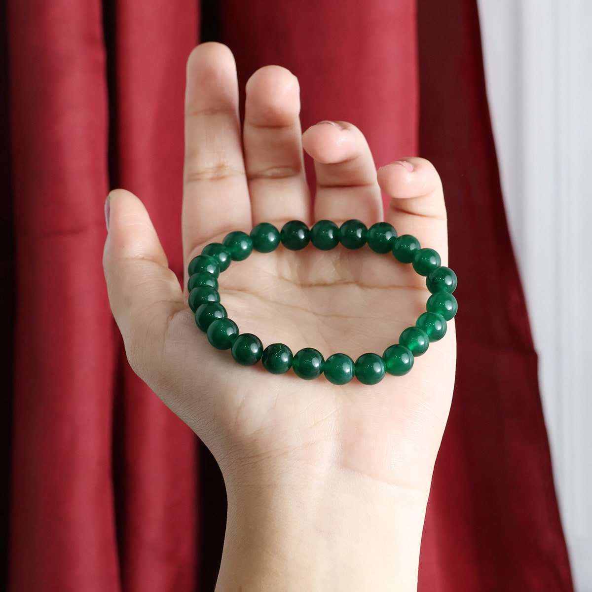 A beautiful Green Jade Round Beads Bracelet showcasing natural jade beads in various sizes, elegantly strung on an elastic band.