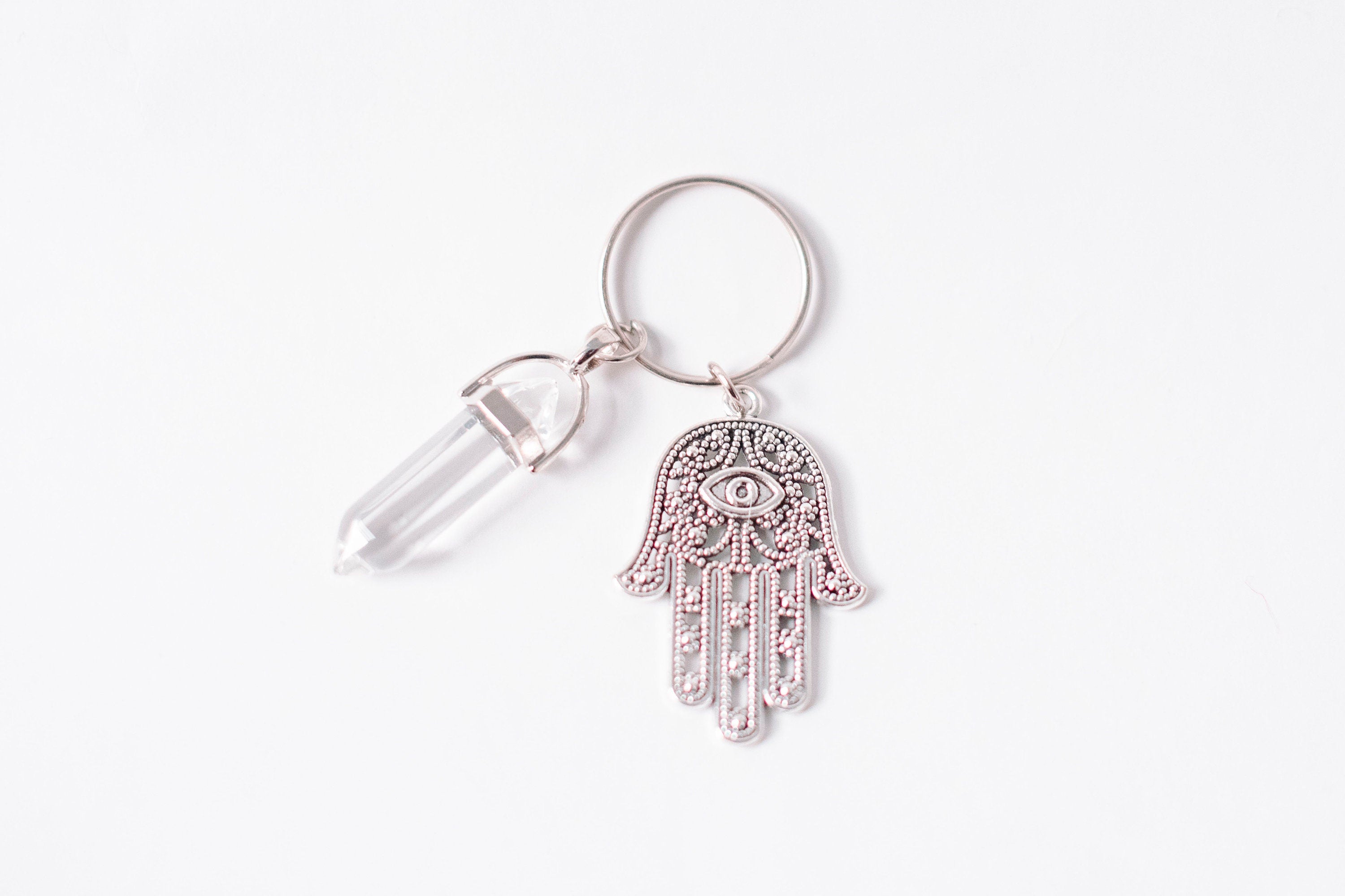 Hamsa & Clear Quartz Key Chain featuring an intricate Hamsa design and a Clear Quartz stone, accompanied by a Hamsa Prayer Card.