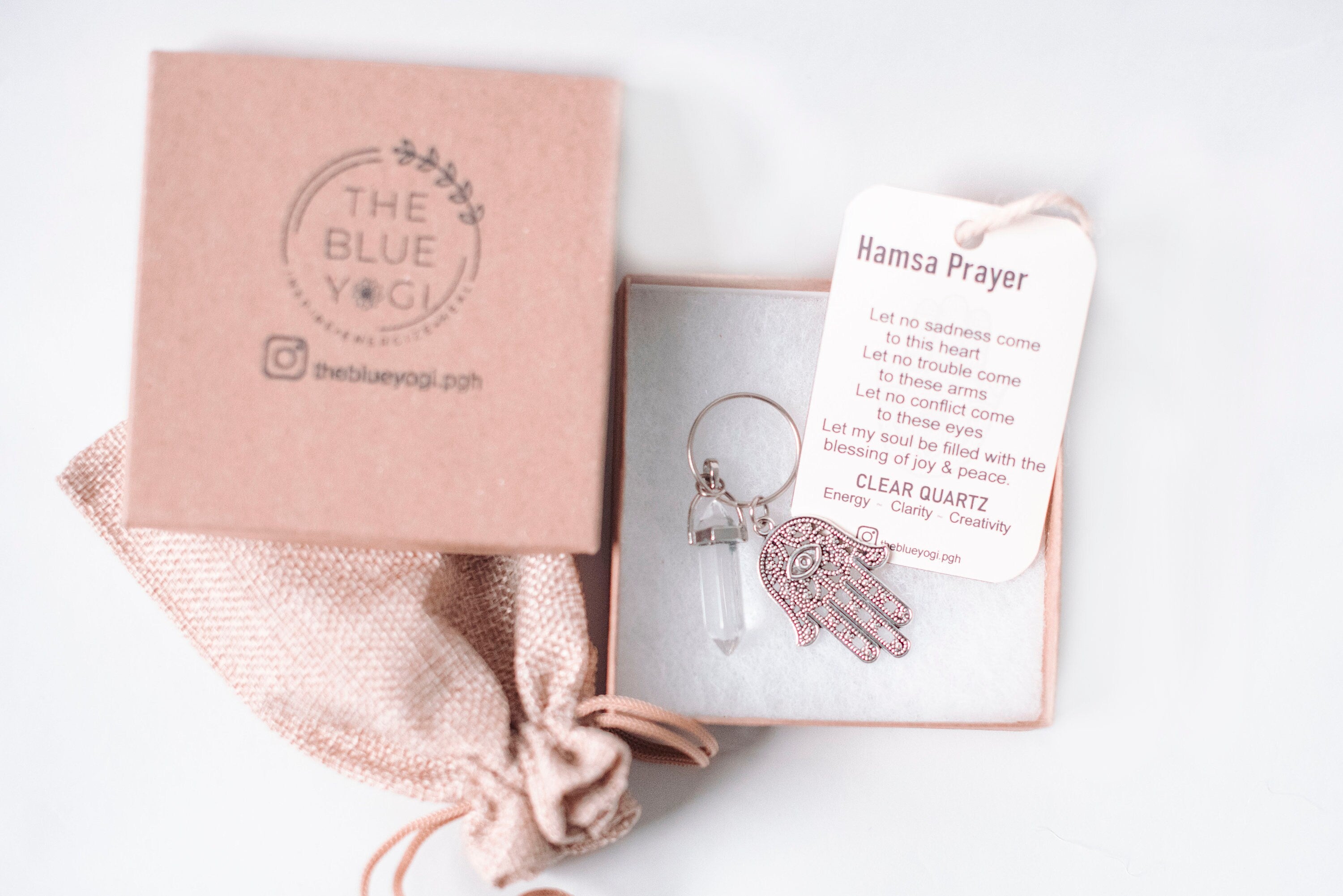 Hamsa & Clear Quartz Key Chain featuring an intricate Hamsa design and a Clear Quartz stone, accompanied by a Hamsa Prayer Card.