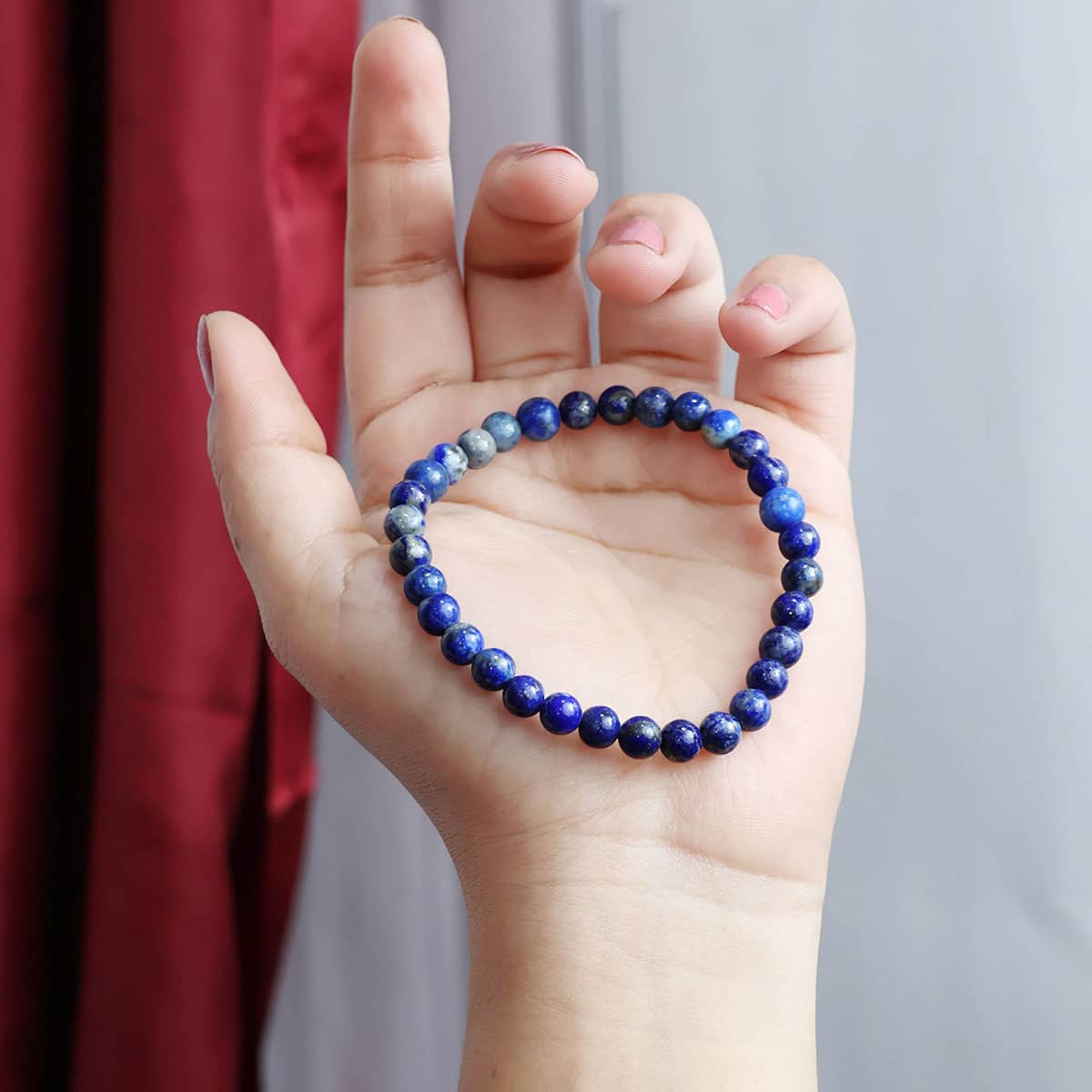 Lapis Lazuli Round Beads Bracelet showcasing deep blue beads with gold flecks, elegantly strung on elastic for a comfortable fit.