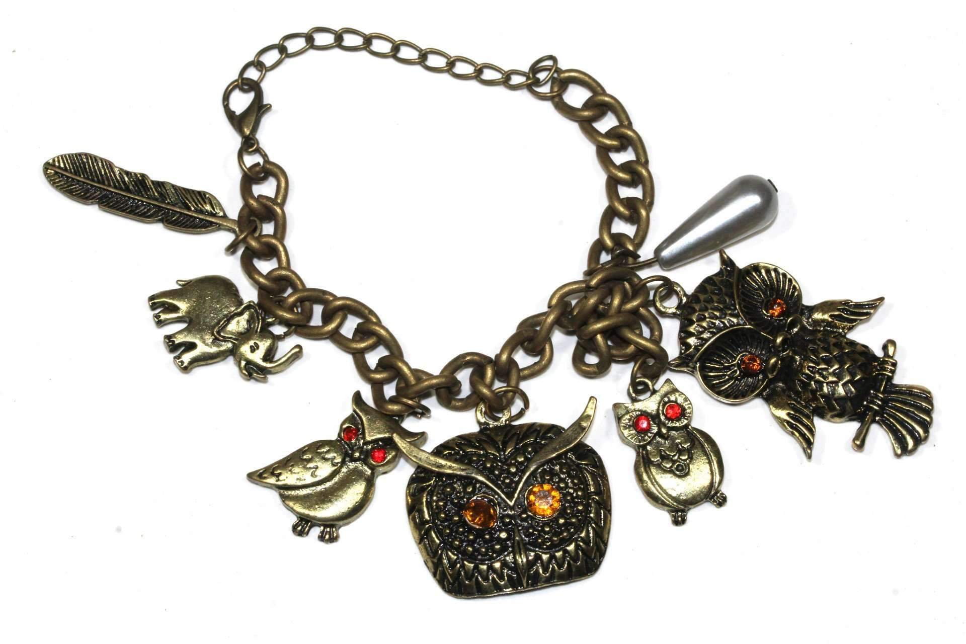 Antique style charm bracelet featuring owl, elephant, and feather charms with glowing amber and red eyes.