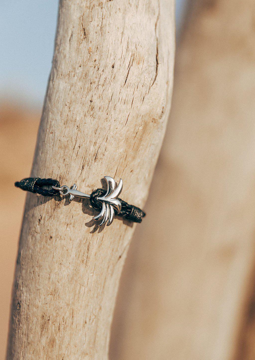 Palmband - Starlight featuring a braided black leather band and a unique palm tree anchor design.